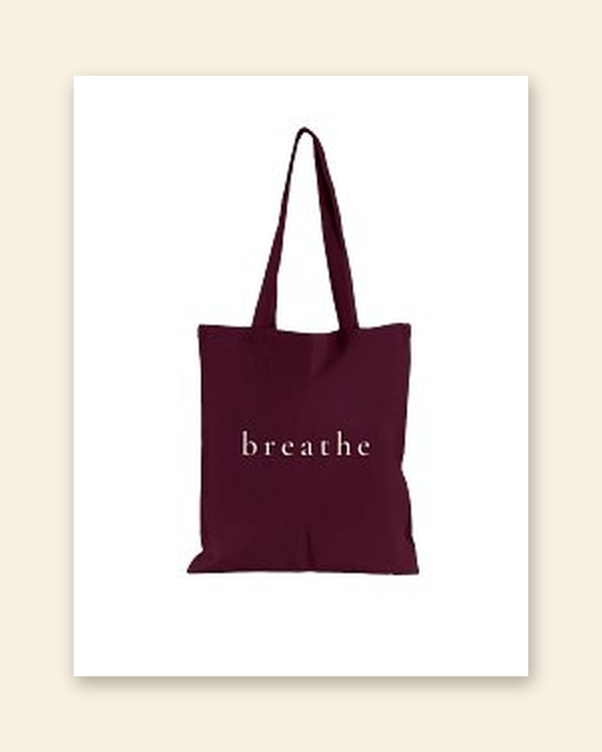 Shop mockup of the front of the Breathe Tote in burgundy canvas: the single word breathe in soft cream serif lettering, on a white card