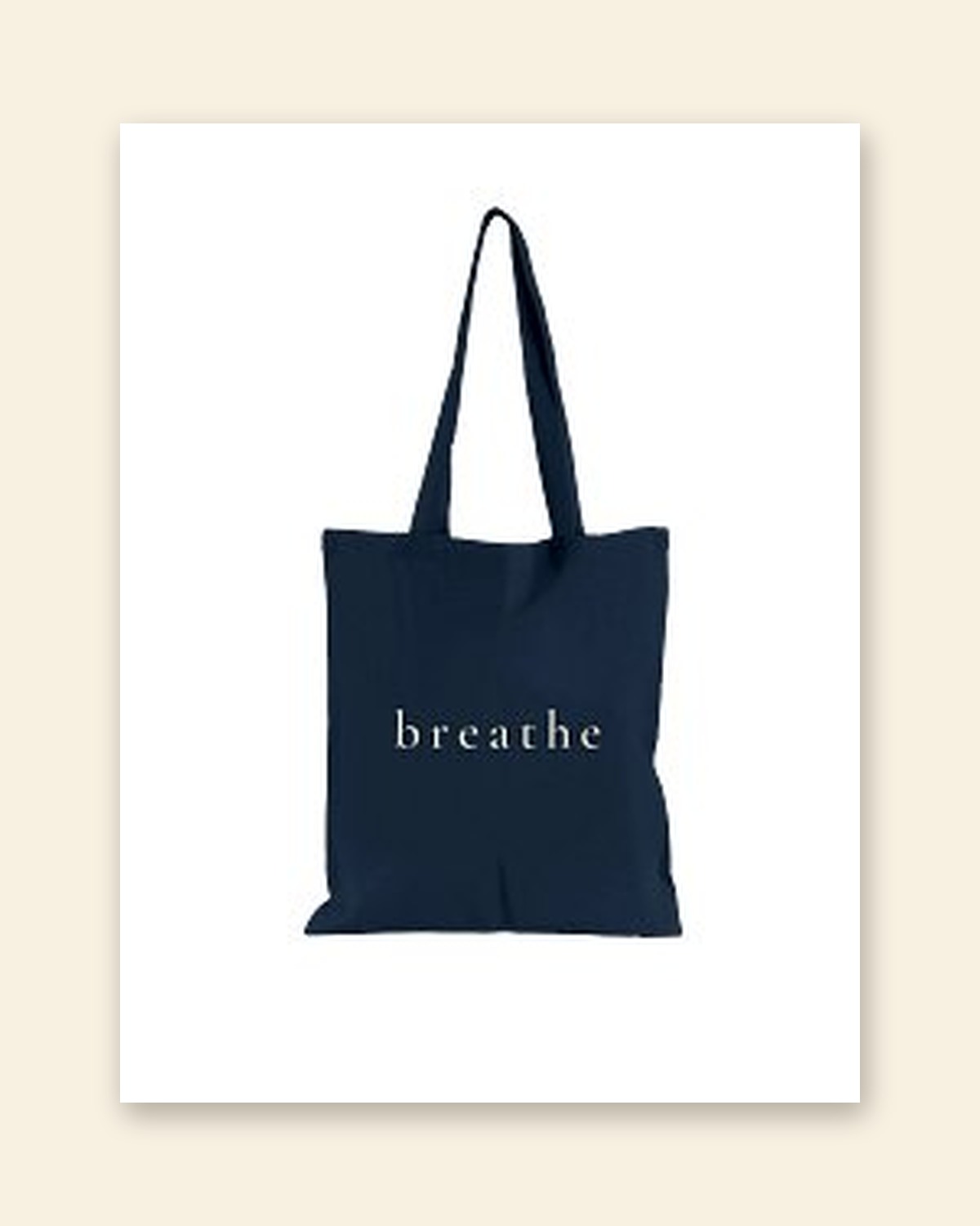 Shop mockup of the front of the Breathe Tote in navy canvas: the single word breathe in cream serif lettering, on a white card