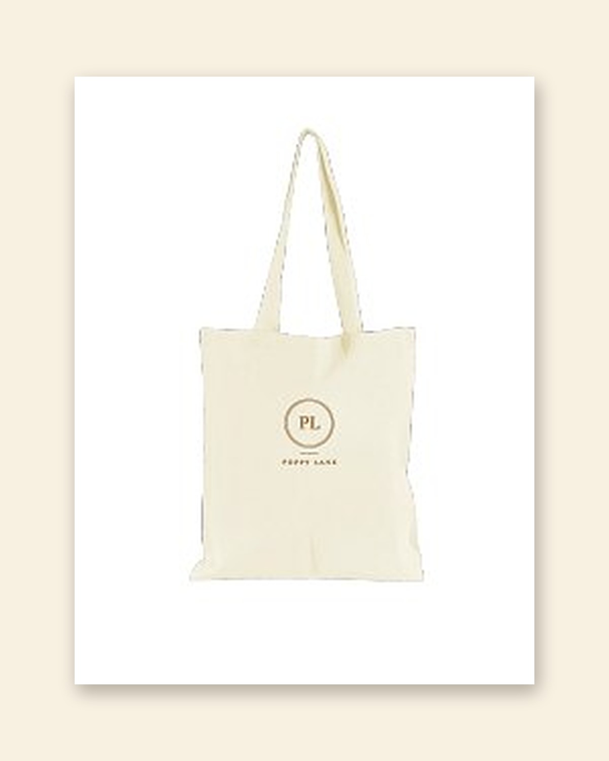 Shop mockup of the Monogram Tote in natural canvas: the PL monogram in an old gold ring with the words Poppy Lane beneath, on a white card