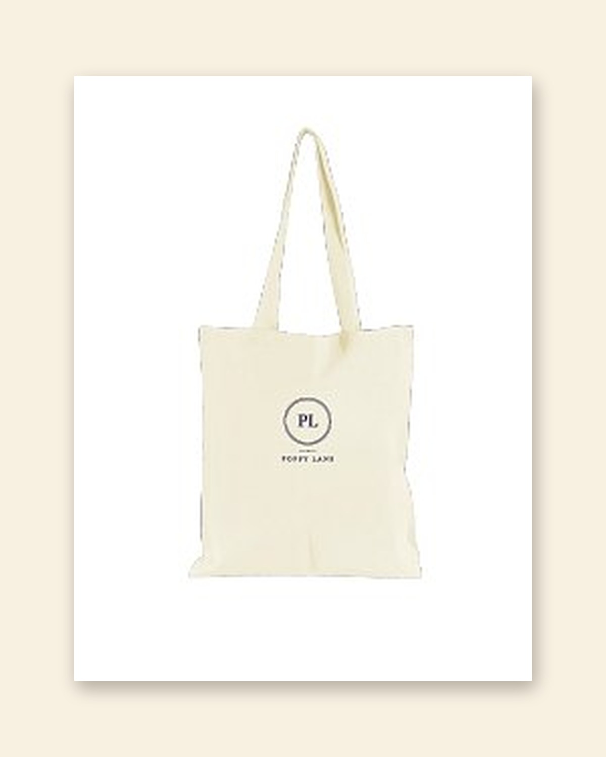 Shop mockup of the Monogram Tote in natural canvas: the PL monogram in a navy ring with the words Poppy Lane beneath, on a white card