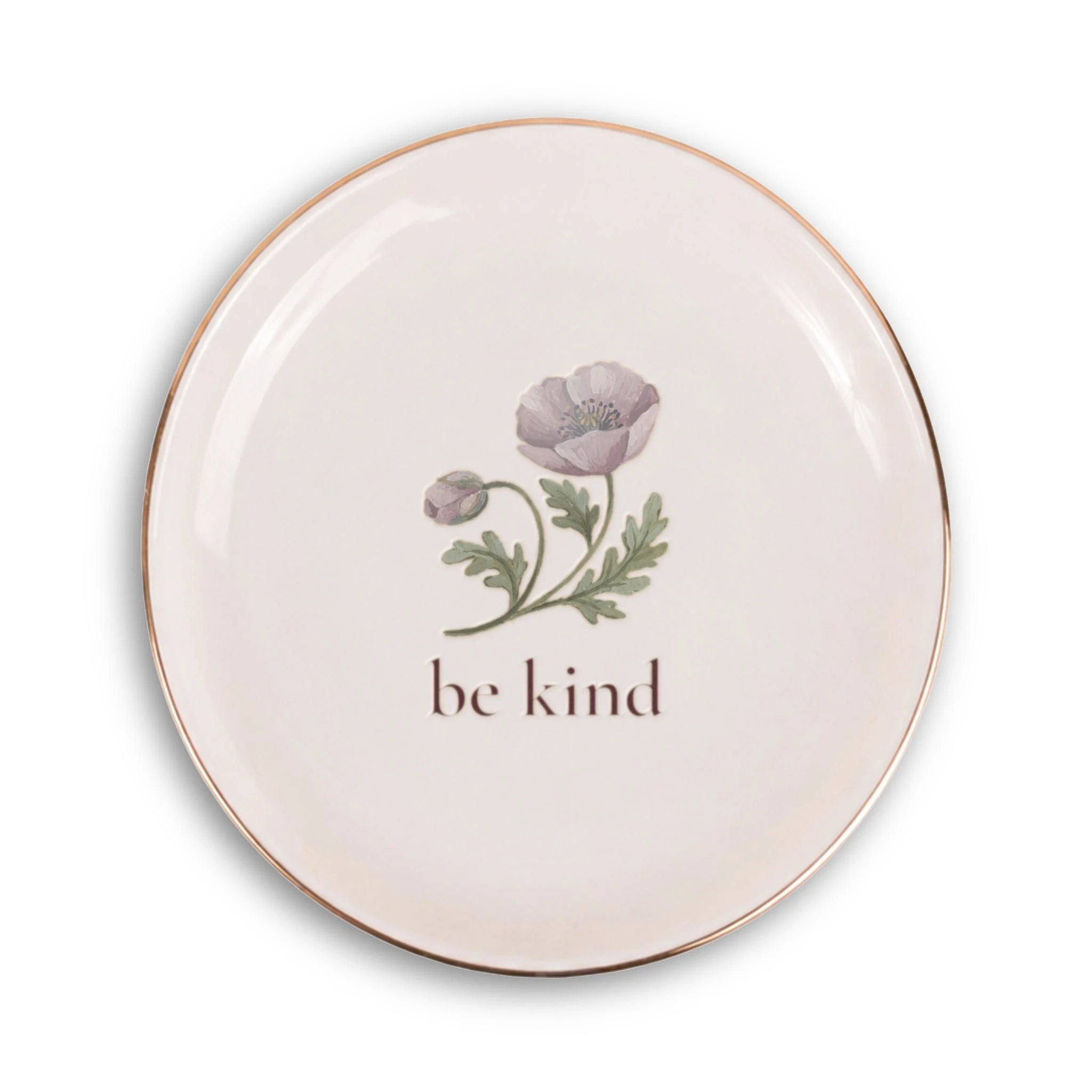 The Be Kind trinket tray: a round glossy white ceramic dish with a thin gold rim, a painted mauve poppy at its center, and the words be kind beneath it